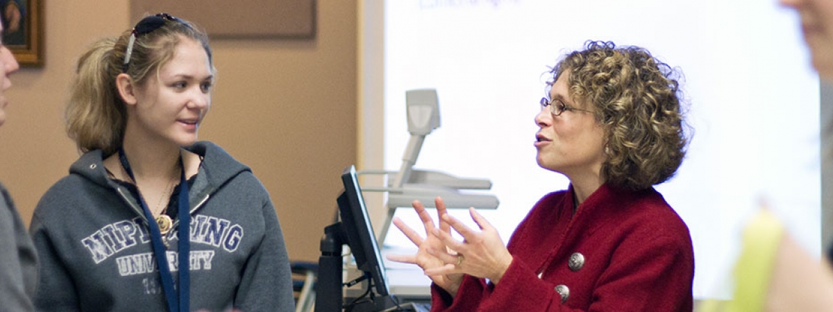 a professor talking with two students